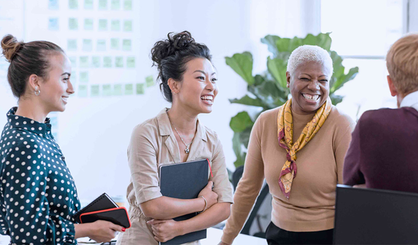 Várias pessoas sorridentes num ambiente de trabalho profissional.